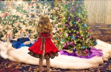 圣诞女孩站在圣诞树下兴奋的小女孩